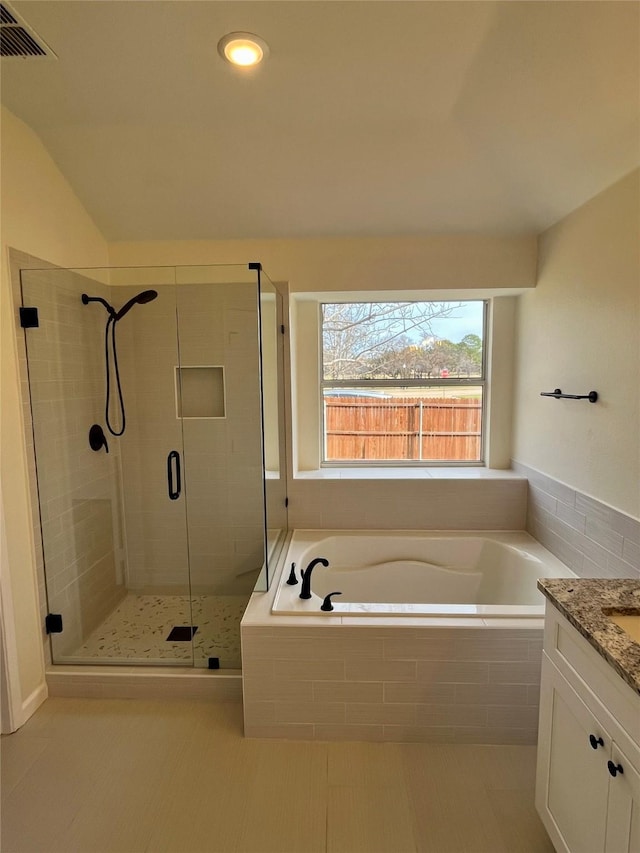 bathroom with vaulted ceiling, vanity, and shower with separate bathtub