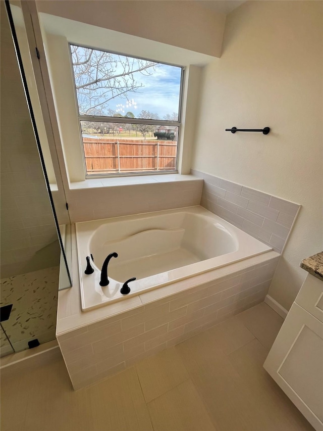 bathroom featuring tiled bath and tile patterned floors