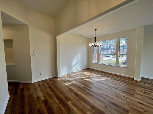 unfurnished dining area with dark wood-type flooring and a chandelier