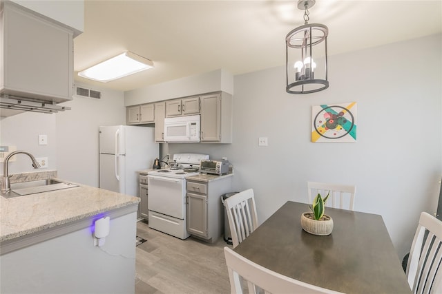 kitchen featuring decorative light fixtures, light hardwood / wood-style floors, sink, white appliances, and gray cabinetry