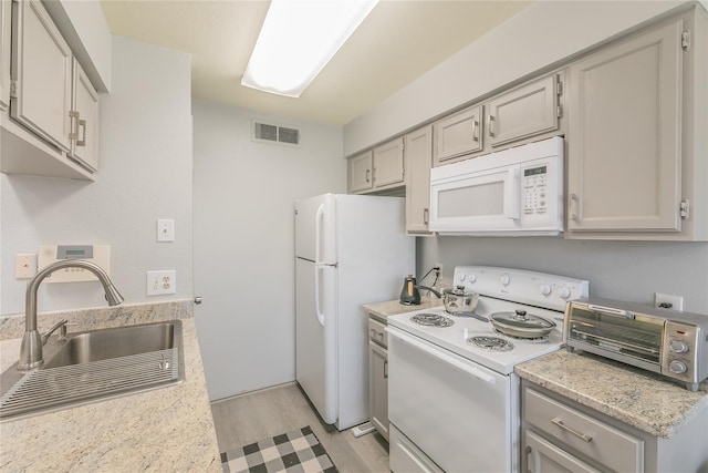 kitchen with gray cabinets, sink, white appliances, and light hardwood / wood-style flooring