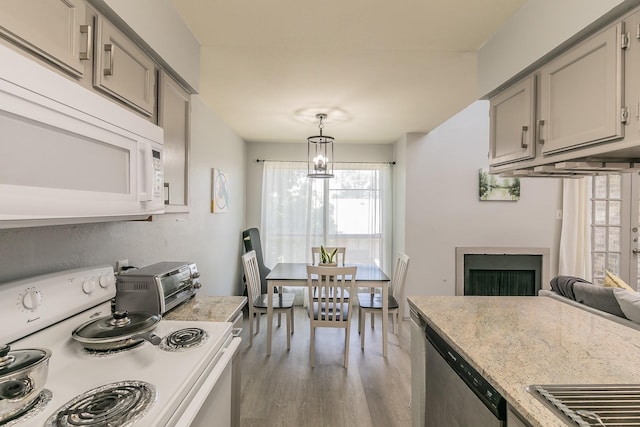 kitchen with pendant lighting, light hardwood / wood-style floors, white appliances, and gray cabinets