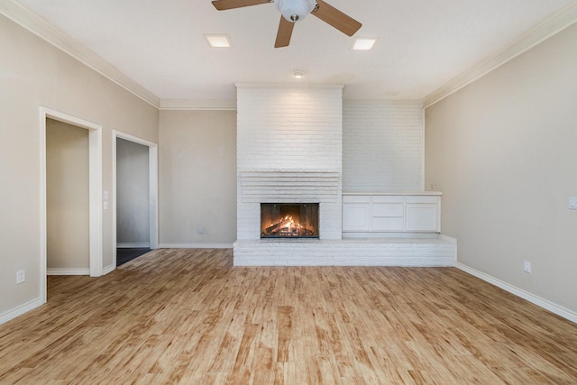 unfurnished living room with ornamental molding, a fireplace, baseboards, and wood finished floors