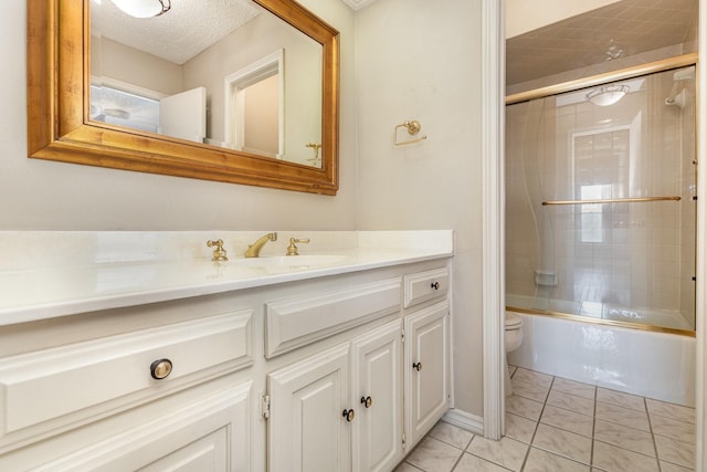 full bathroom with shower / bath combination with glass door, vanity, toilet, tile patterned floors, and a textured ceiling