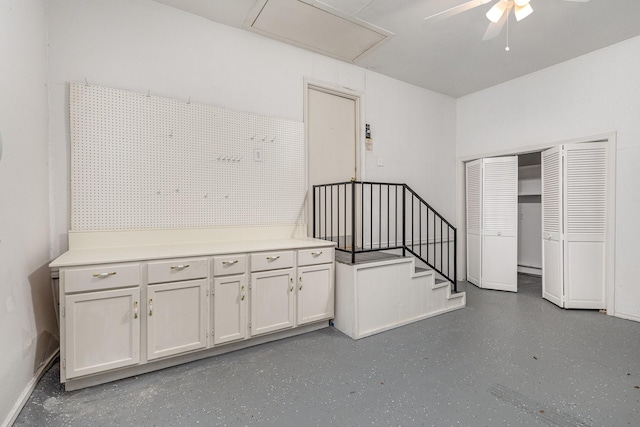 stairs featuring ceiling fan