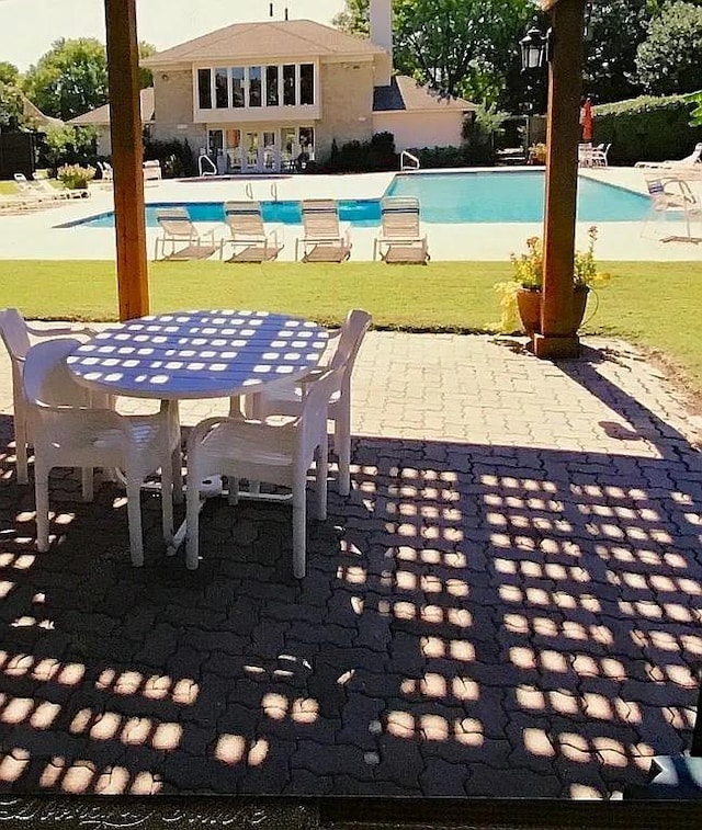 view of pool featuring a patio and a lawn