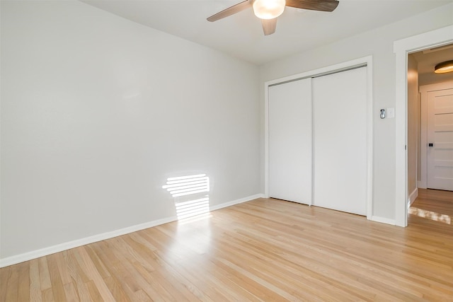 unfurnished bedroom with light wood-type flooring, ceiling fan, and a closet