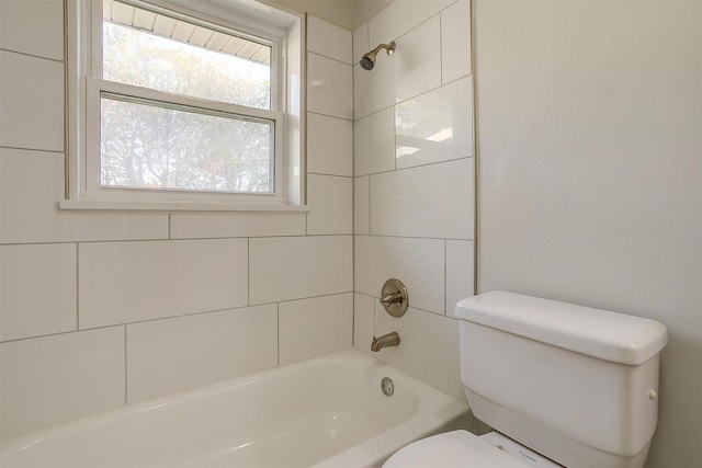 bathroom with toilet and tiled shower / bath combo