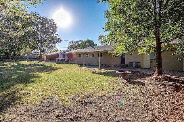 view of yard with central AC and a patio