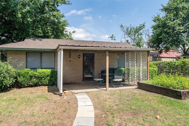 back of property featuring a patio area and a lawn