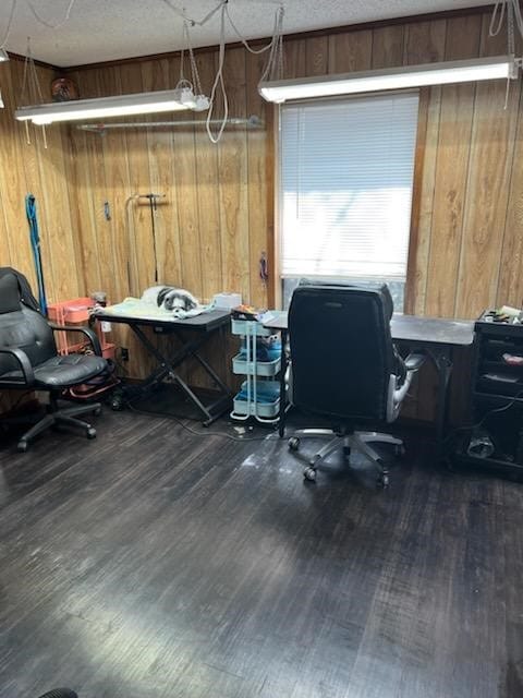 office space with dark hardwood / wood-style flooring, wooden walls, and a textured ceiling