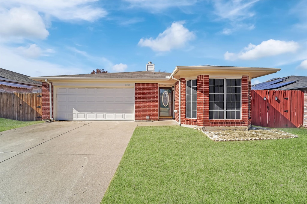 ranch-style house with a garage and a front lawn