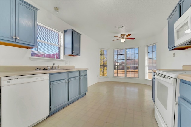 kitchen with blue cabinets, sink, white appliances, a textured ceiling, and ceiling fan