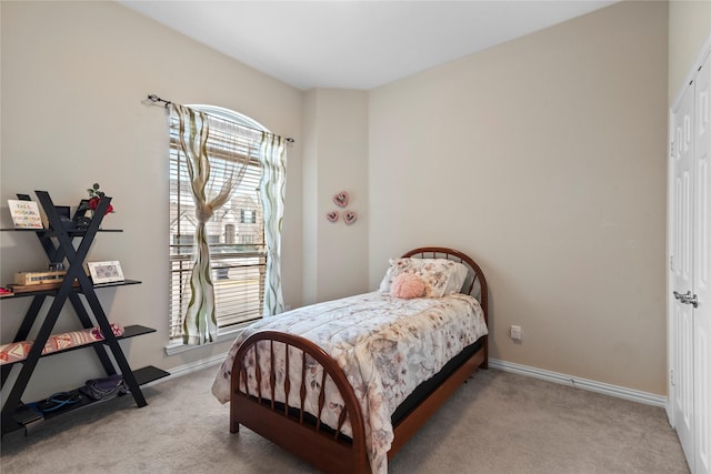 bedroom with light carpet and a closet