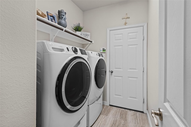 clothes washing area with separate washer and dryer and light hardwood / wood-style floors