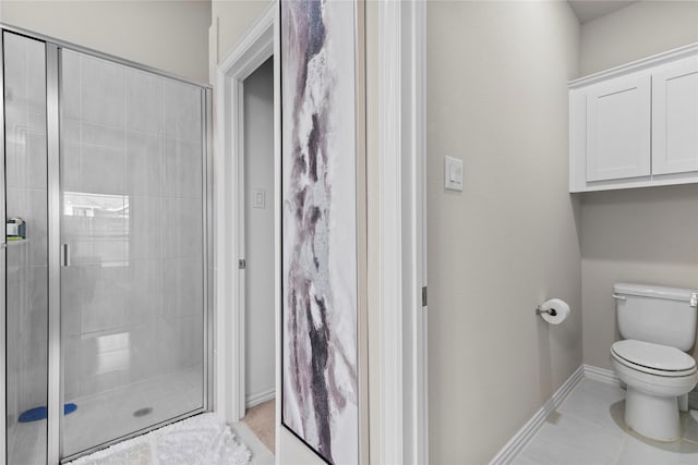 bathroom with toilet, tile patterned flooring, and a shower with shower door