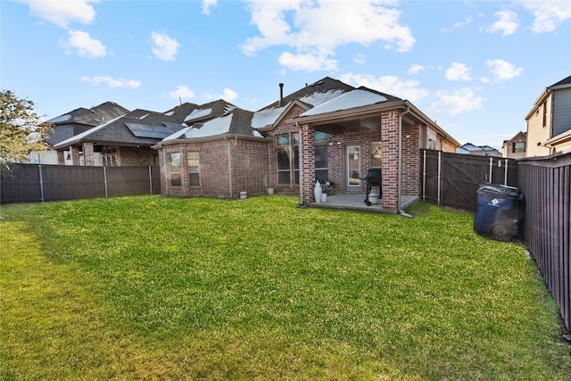 back of property with a yard and a patio