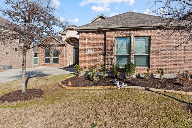 view of front of home featuring a front yard and central air condition unit