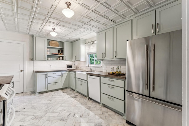 kitchen featuring dishwasher, wooden counters, sink, high end fridge, and stove