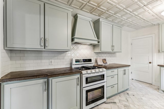 kitchen with premium range hood, range with two ovens, and gray cabinetry