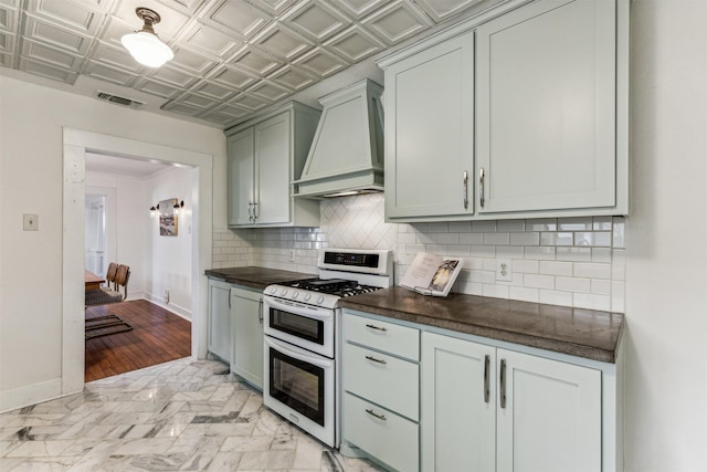 kitchen with double oven range, custom exhaust hood, and tasteful backsplash