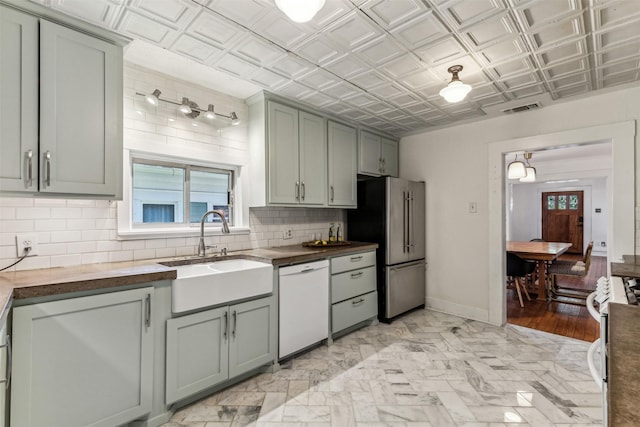 kitchen featuring sink, backsplash, appliances with stainless steel finishes, and wood counters