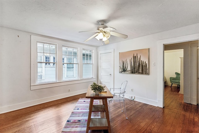 interior space featuring ceiling fan, dark wood-type flooring, and a textured ceiling