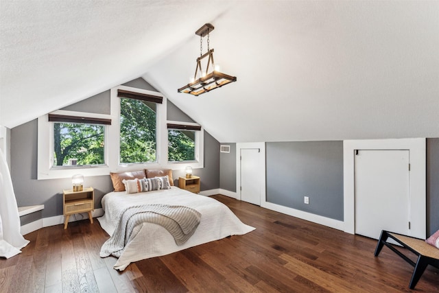 bedroom featuring a textured ceiling, lofted ceiling, and dark hardwood / wood-style floors