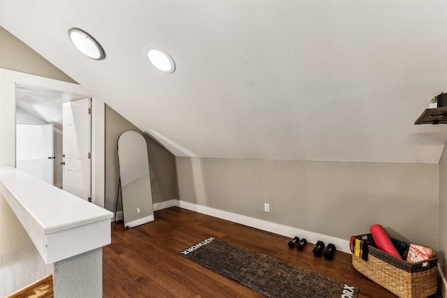 bonus room with dark wood-type flooring and vaulted ceiling