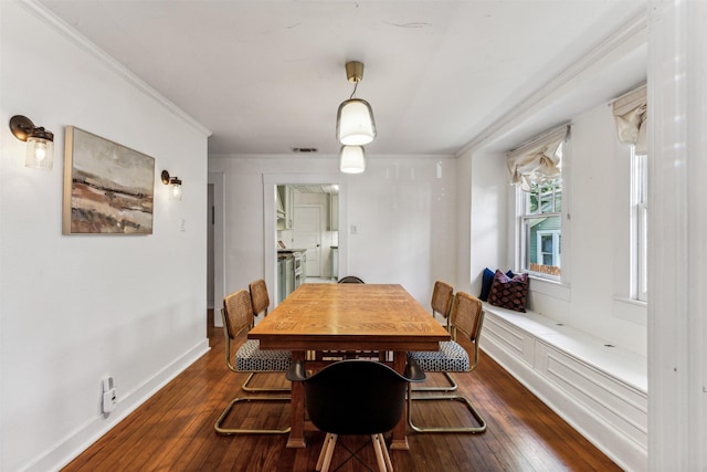 dining room with dark hardwood / wood-style flooring and ornamental molding