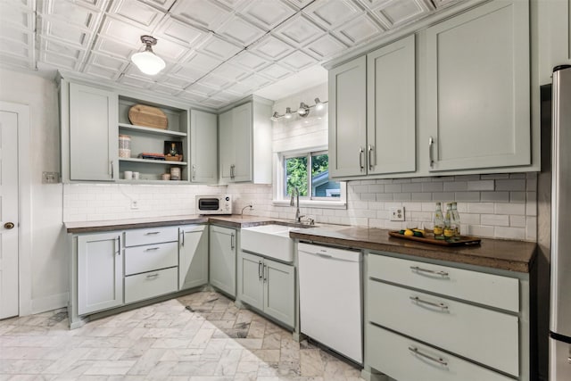 kitchen with sink, stainless steel fridge, dishwasher, and gray cabinetry