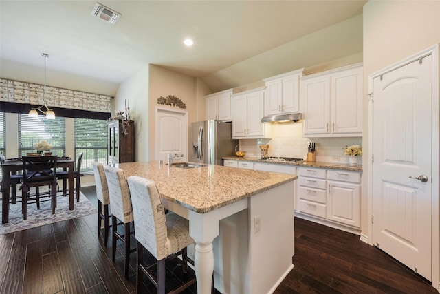 kitchen featuring appliances with stainless steel finishes, white cabinetry, and an island with sink