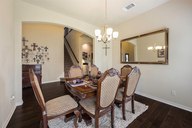 dining space with dark hardwood / wood-style flooring and an inviting chandelier