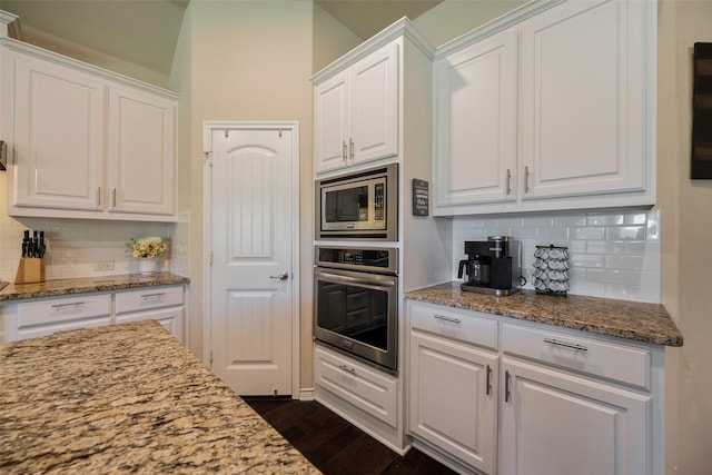 kitchen with light stone counters, white cabinetry, appliances with stainless steel finishes, and tasteful backsplash