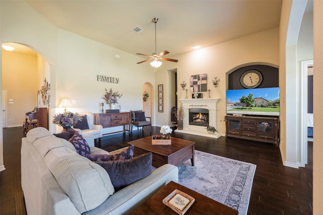 living room with ceiling fan, dark hardwood / wood-style flooring, and lofted ceiling