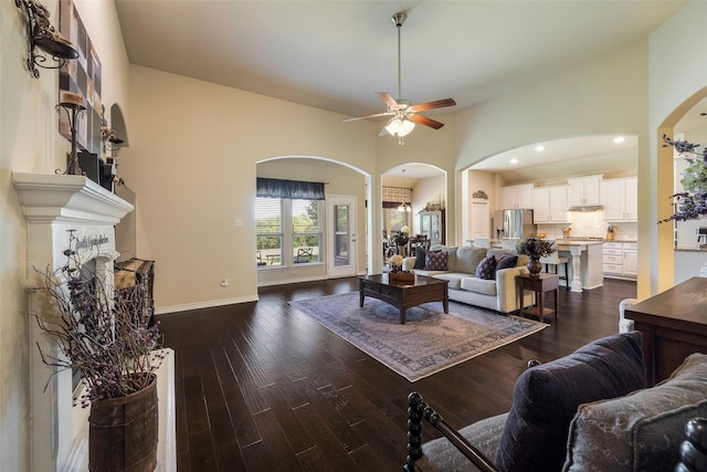 living room with ceiling fan and dark hardwood / wood-style flooring