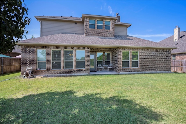 rear view of property with a lawn