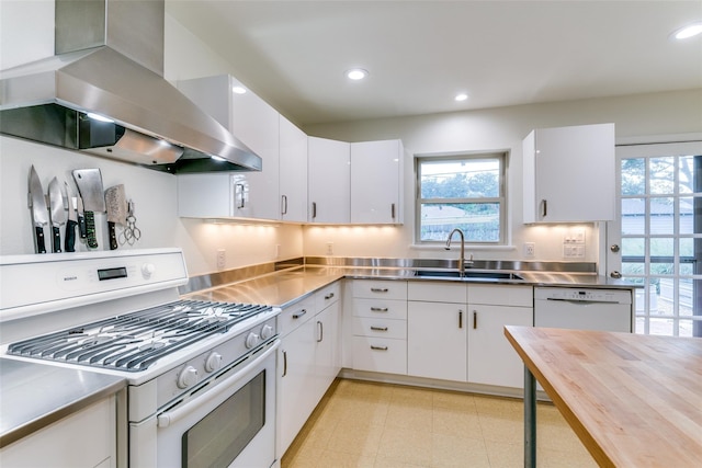 kitchen featuring stainless steel counters, sink, white appliances, white cabinetry, and ventilation hood