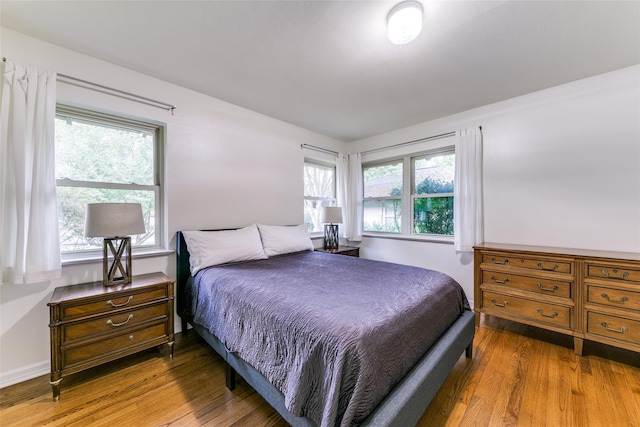 bedroom featuring dark hardwood / wood-style flooring and multiple windows