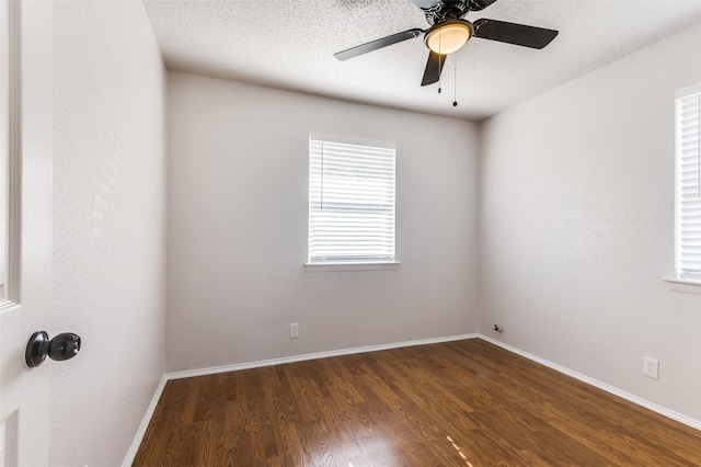 empty room with a textured ceiling, ceiling fan, and dark hardwood / wood-style floors