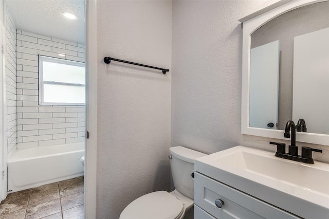 full bathroom with toilet, vanity, a textured ceiling, and tiled shower / bath