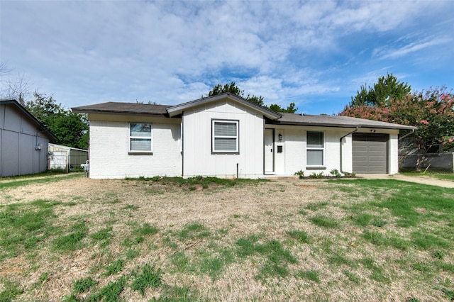 ranch-style home with a garage and a front lawn