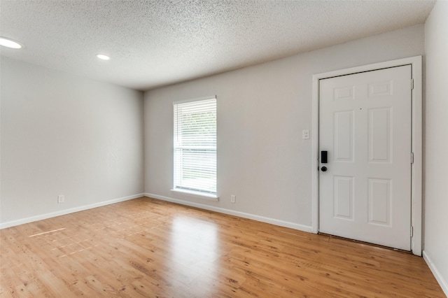 entryway featuring a textured ceiling and light hardwood / wood-style flooring