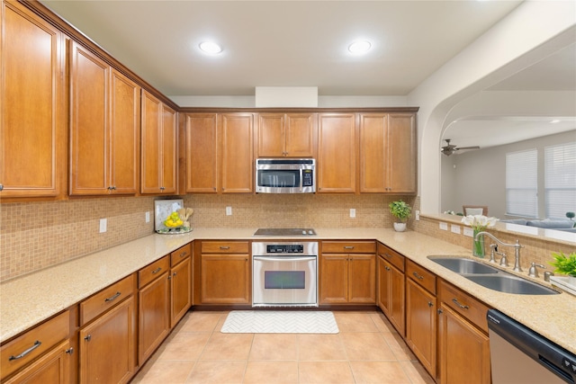 kitchen with light tile patterned floors, backsplash, appliances with stainless steel finishes, and sink