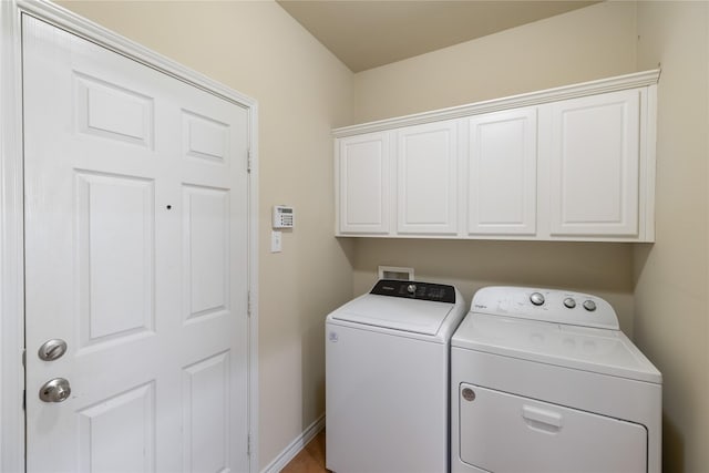 washroom with cabinets and washing machine and dryer