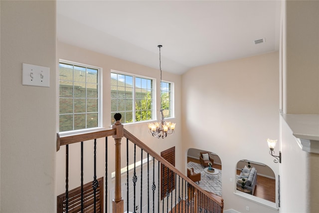 stairway featuring lofted ceiling and an inviting chandelier