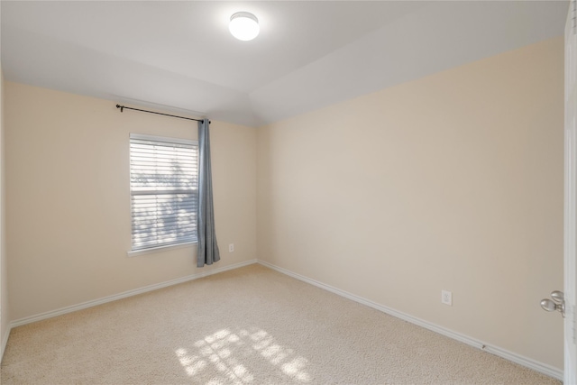 unfurnished room featuring lofted ceiling and light colored carpet