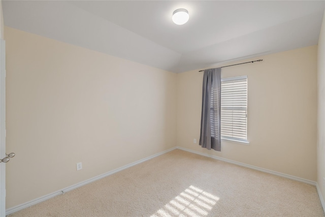 empty room with lofted ceiling and light colored carpet