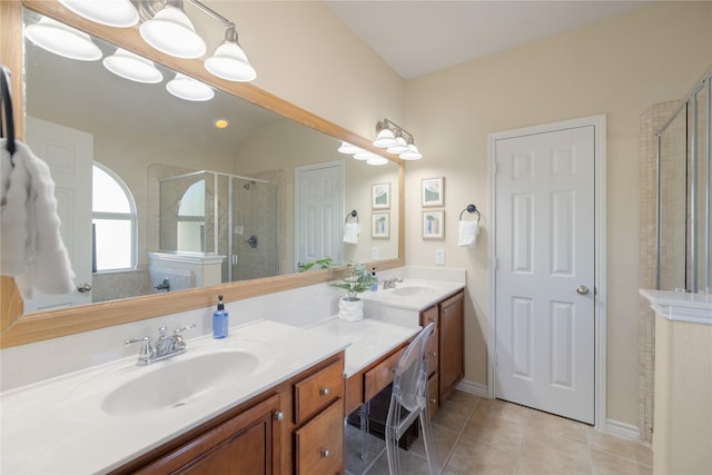 bathroom featuring a shower with shower door, vanity, and tile patterned floors