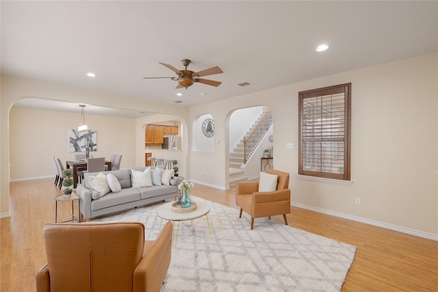 living room with light wood-type flooring and ceiling fan